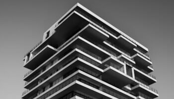 A striking black and white photo of a modern high-rise building with unique geometric designs.