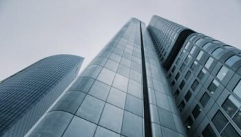 Low angle view of modern skyscrapers with glass and steel design. Perfect for corporate imagery.